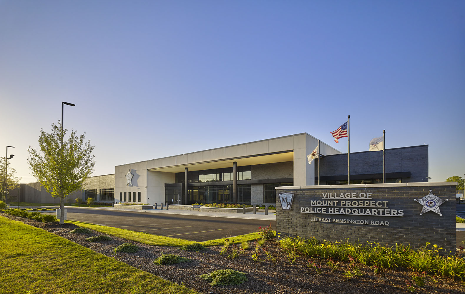 Sunny outside landscape of the new Mount Prospect Police Headquarters showing the entrance sign and entire building.
