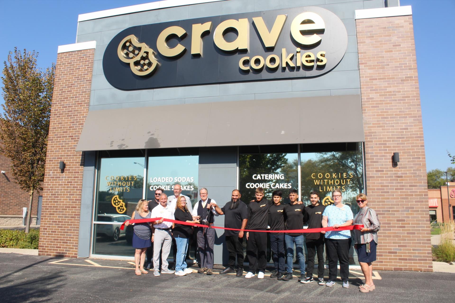 people holding ribbon in front of Crave Cookies
