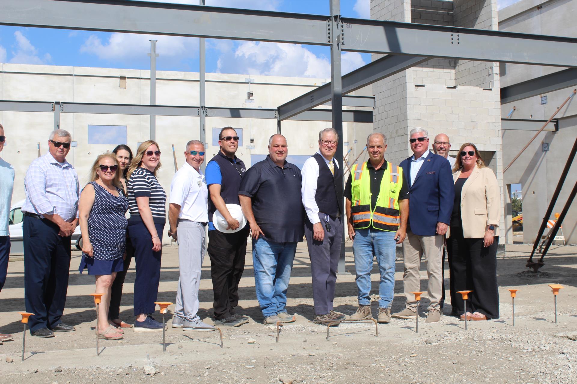 people posing in front of construction site for DiMeo Groundbreaking