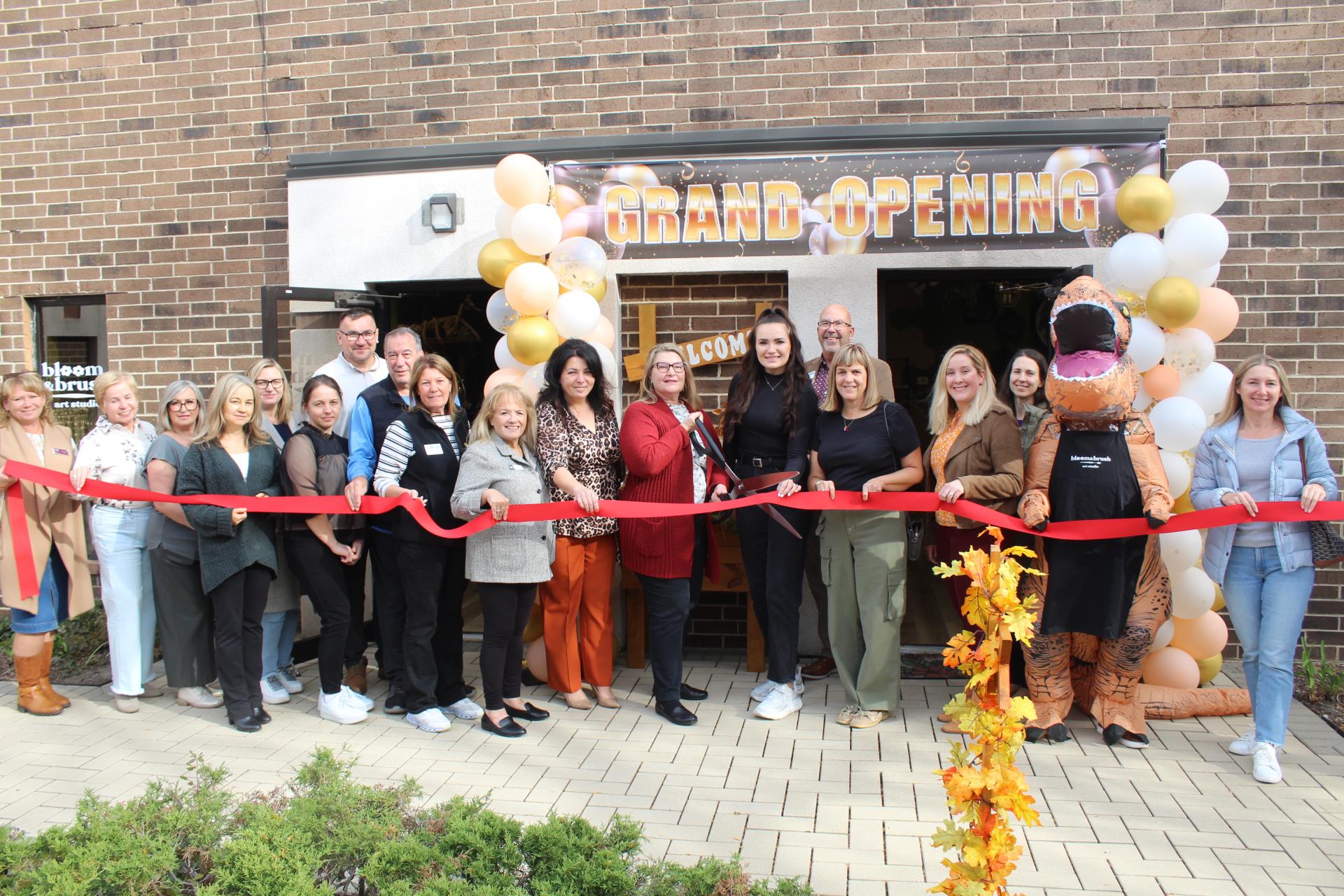 People holding ribbon cutting in front of Bloom & Brush