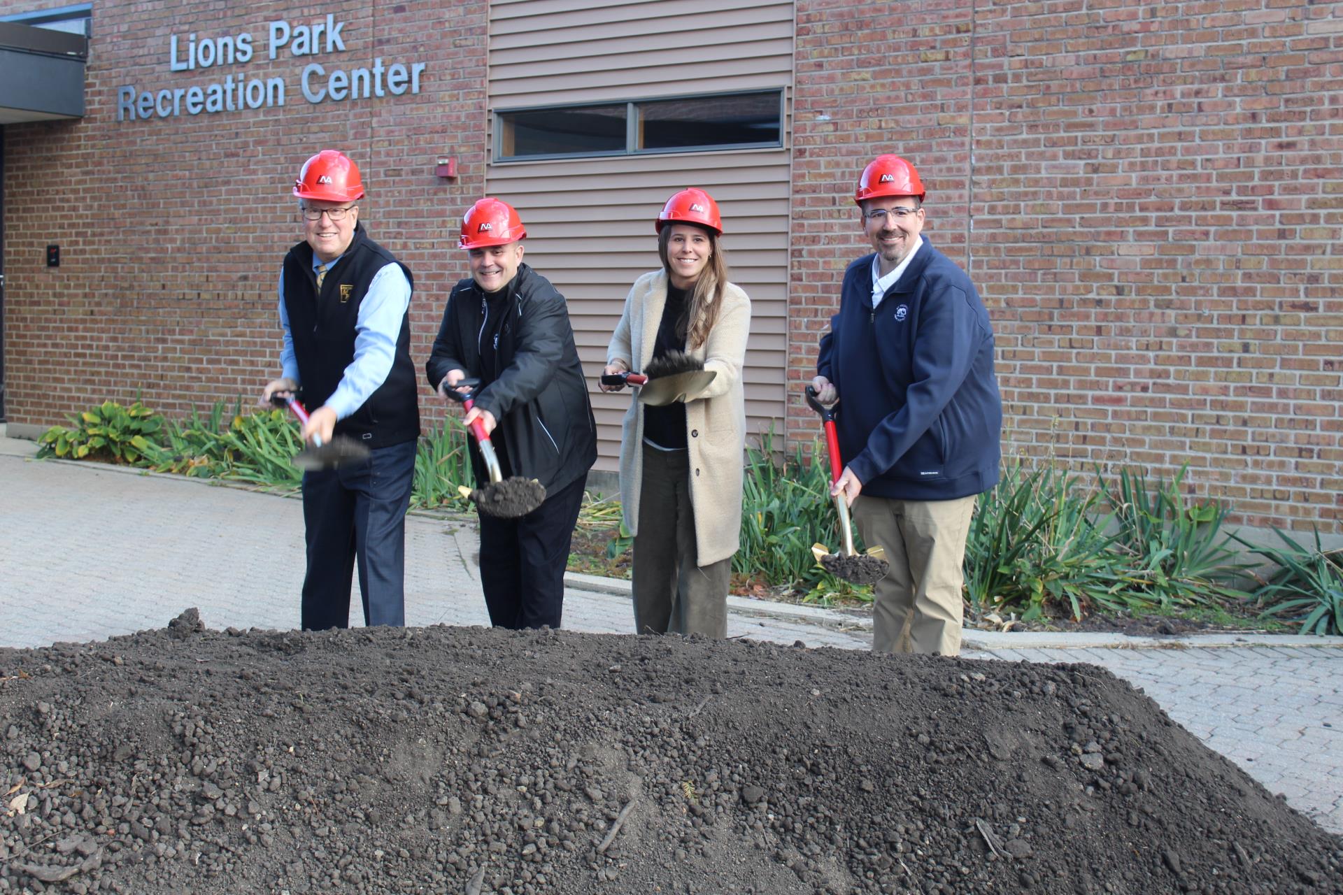 People with shovels of dirt in front of Lions Park Rec Center