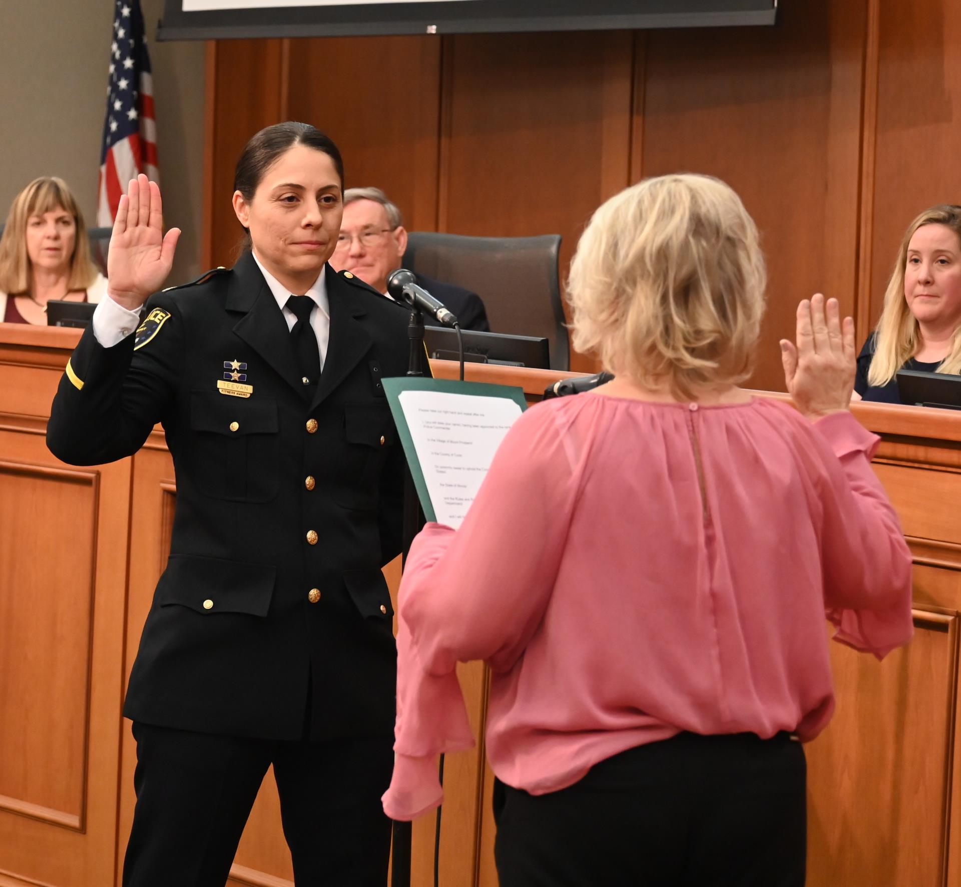 female police officer raising right hand taking oath of office
